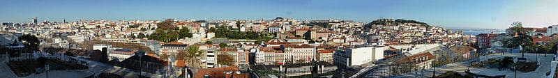 <strong>Vista panorâmica de Lisboa a partir do Miradouro de São Pedro de Alcântara</strong>. Foto <a href="https://creativecommons.org/licenses/by-sa/4.0/deed.en" target="_blank" rel="noopener">CC BY-SA 4.0</a> <a href="https://commons.wikimedia.org/wiki/File:Sao_Pedro_de_Alcantara_Belvedere,_Lisbon.jpg" target="_blank" rel="noopener">Reino Baptista</a>